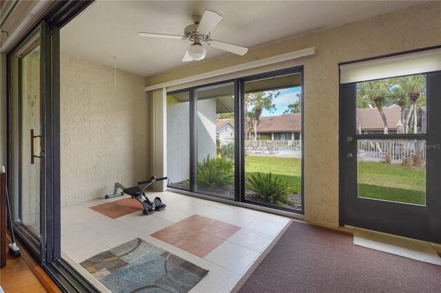 unfurnished sunroom featuring ceiling fan