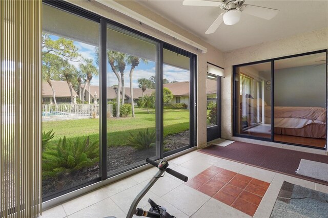 doorway to outside featuring tile patterned flooring and ceiling fan