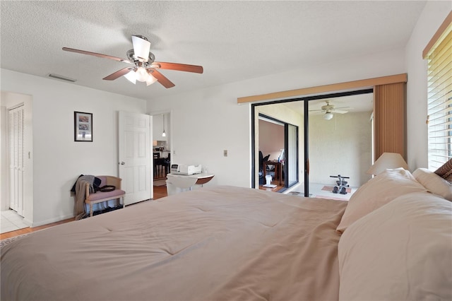 bedroom with access to exterior, a textured ceiling, ceiling fan, and light tile patterned flooring