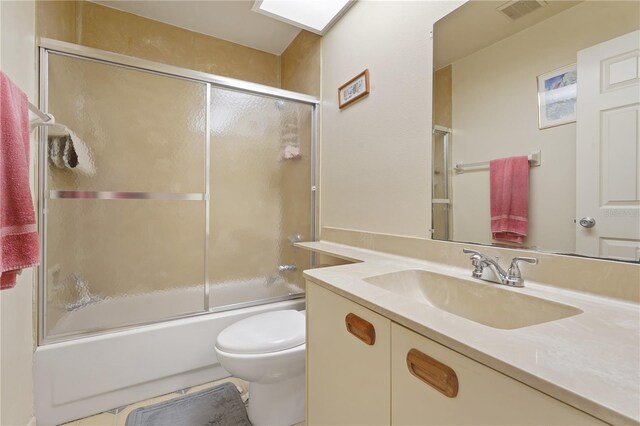 full bathroom featuring tile patterned floors, toilet, combined bath / shower with glass door, and vanity