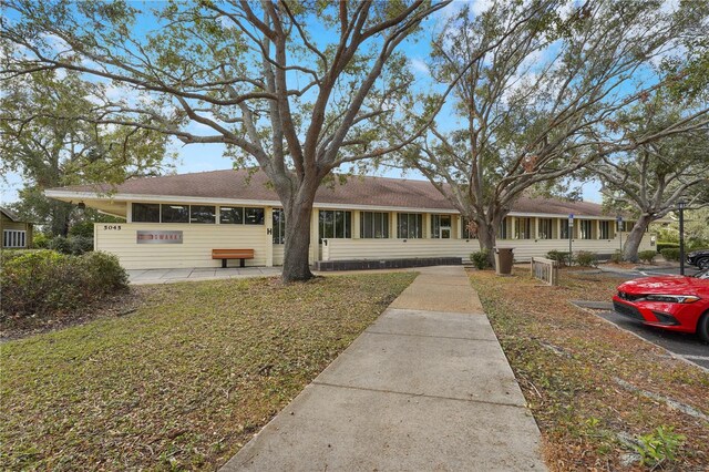 single story home featuring a front lawn