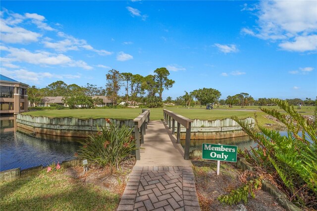 view of property's community with a water view and a yard