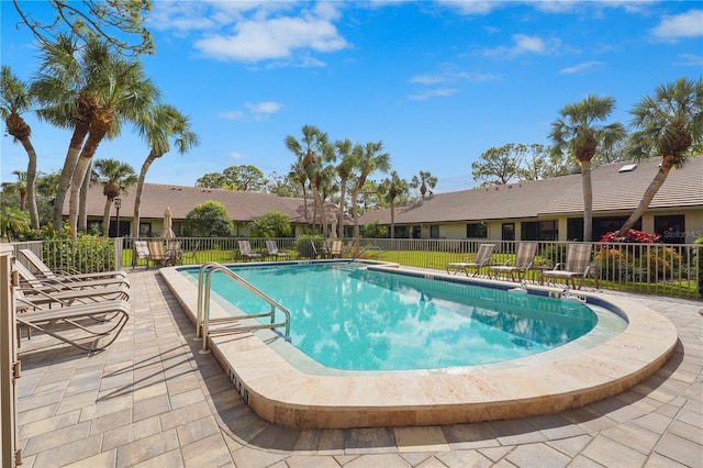 pool with a patio area and fence