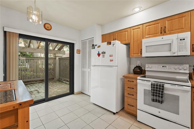 kitchen with white appliances, brown cabinets, decorative light fixtures, light countertops, and light tile patterned flooring