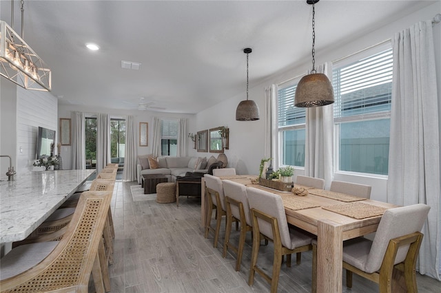 dining area with light wood-type flooring, a wealth of natural light, and ceiling fan