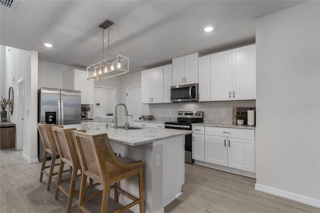 kitchen featuring a kitchen island with sink, white cabinetry, sink, and stainless steel appliances