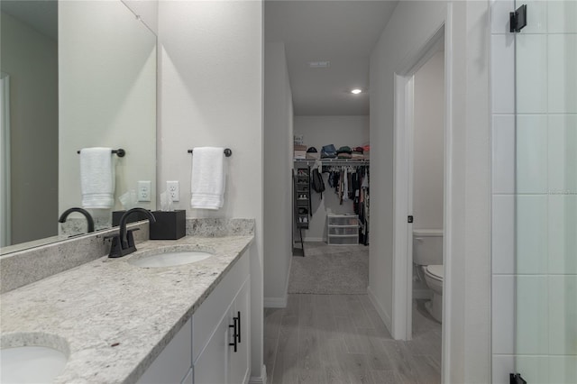 bathroom featuring toilet, vanity, and hardwood / wood-style floors