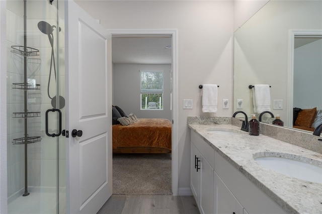 bathroom with an enclosed shower, vanity, and hardwood / wood-style flooring