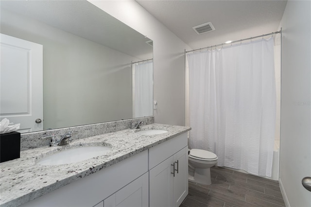 full bathroom with shower / tub combo with curtain, vanity, toilet, and hardwood / wood-style flooring