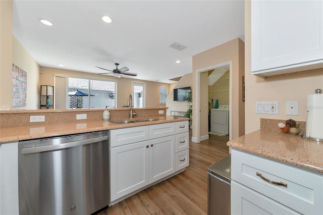 kitchen featuring white cabinetry, sink, stainless steel dishwasher, independent washer and dryer, and light wood-type flooring