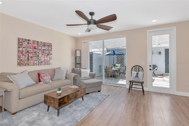 living room featuring ceiling fan, a healthy amount of sunlight, and light hardwood / wood-style floors