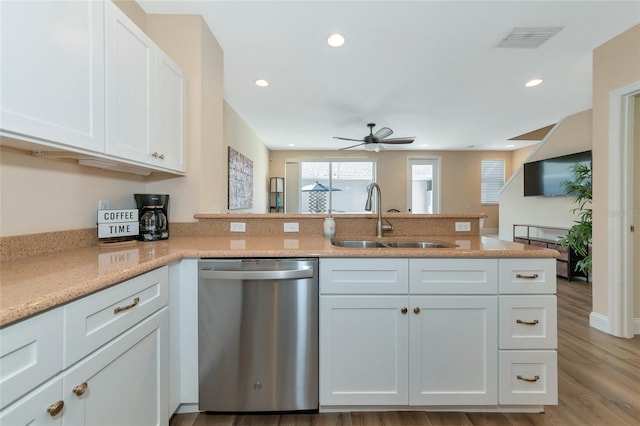 kitchen with kitchen peninsula, stainless steel dishwasher, sink, light hardwood / wood-style flooring, and white cabinetry