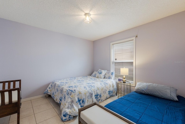 bedroom with a textured ceiling and light tile patterned floors