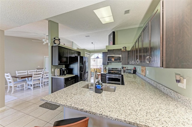 4135 Dover Dr E, Bradenton, FL 34203 - kitchen with appliances with stainless steel finishes, a sink, ceiling fan, a peninsula, and light tile patterned floors
