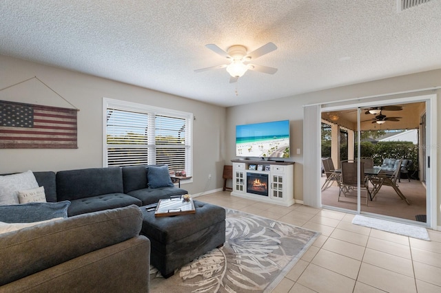 4135 Dover Dr E, Bradenton, FL 34203 - living area with a ceiling fan, light tile patterned flooring, a warm lit fireplace, a textured ceiling, and baseboards