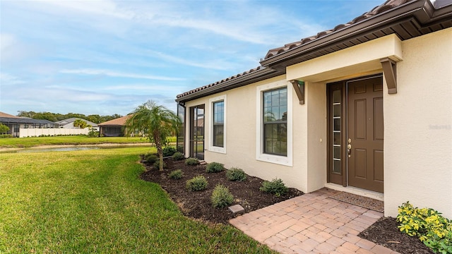 entrance to property with a lawn