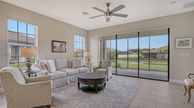 tiled living room with a wealth of natural light and ceiling fan