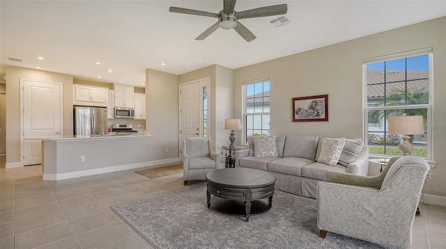 tiled living room featuring ceiling fan and plenty of natural light