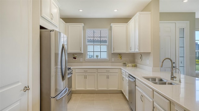 5431 Taliaferro Ct, Palmetto, FL 34221 - kitchen featuring stainless steel appliances, a sink, light tile patterned floors, light countertops, and white cabinetry