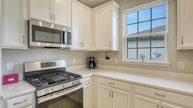 kitchen with white cabinets and appliances with stainless steel finishes