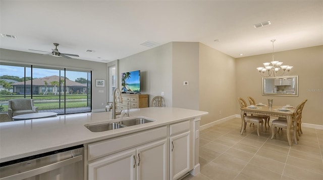 kitchen featuring decorative light fixtures, light tile patterned floors, sink, white cabinets, and stainless steel dishwasher