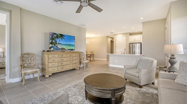 living room featuring light tile patterned flooring, ceiling fan, and sink