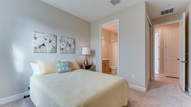 bedroom featuring ensuite bathroom and light carpet