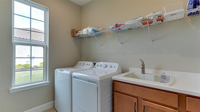 laundry room with cabinets, separate washer and dryer, a healthy amount of sunlight, and sink