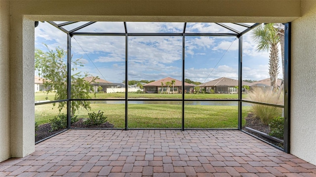 unfurnished sunroom featuring a water view