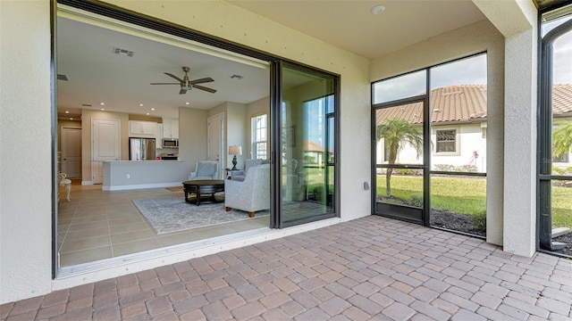 unfurnished sunroom with ceiling fan and plenty of natural light