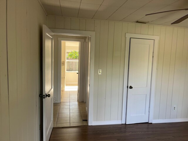 hallway featuring dark wood-style flooring and baseboards