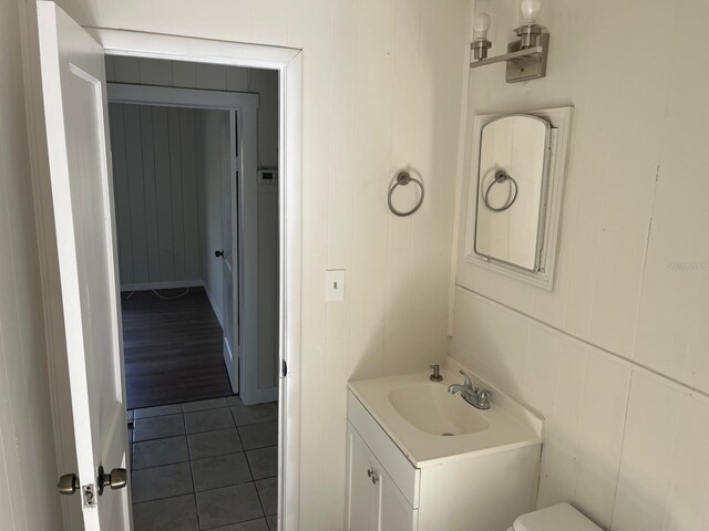 half bathroom featuring tile patterned flooring and vanity