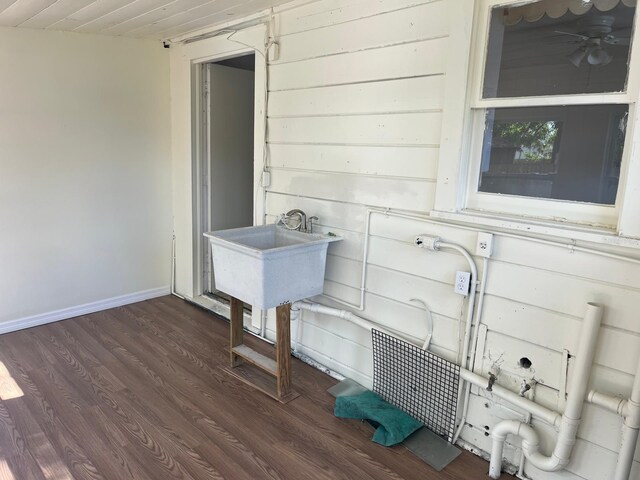 interior space featuring a sink, wood finished floors, and baseboards