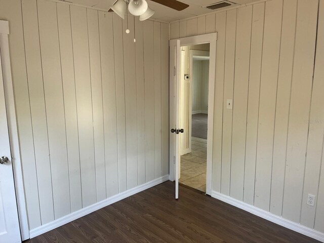 unfurnished bedroom featuring dark wood-style floors, baseboards, visible vents, and a ceiling fan