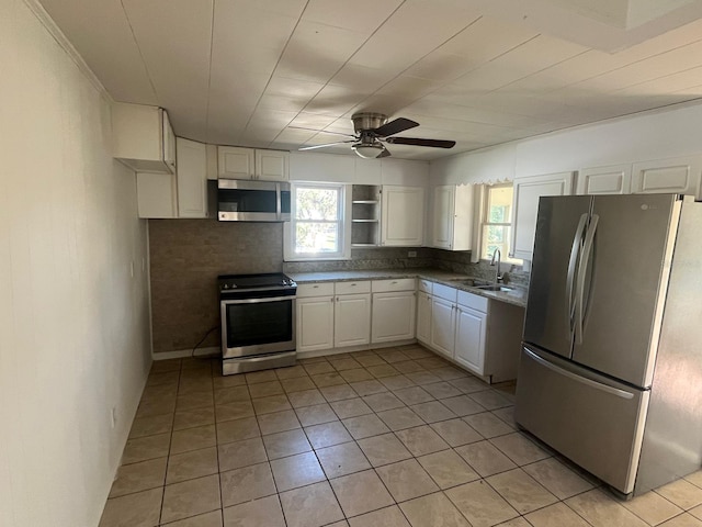 kitchen featuring stainless steel appliances, a healthy amount of sunlight, a sink, and white cabinets