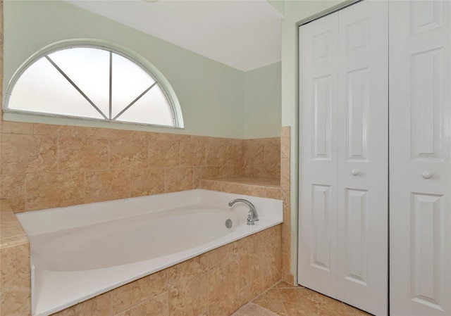 bathroom featuring tile patterned flooring and a relaxing tiled tub