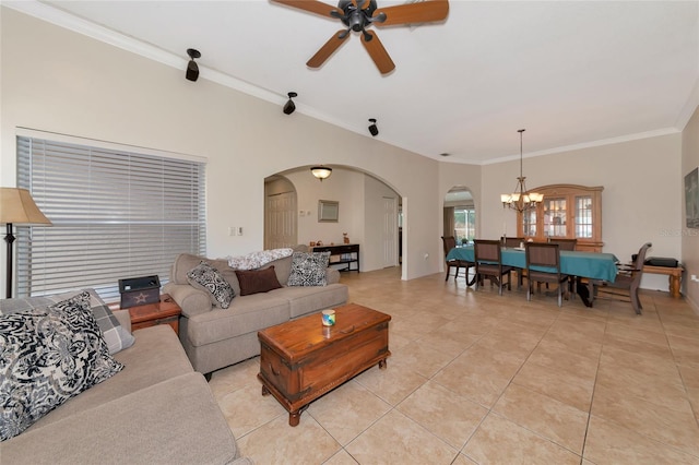 living area featuring light tile patterned flooring, ceiling fan with notable chandelier, arched walkways, and ornamental molding