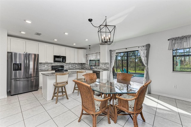 tiled dining space featuring a chandelier and sink