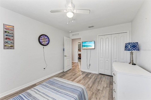 bedroom with light hardwood / wood-style flooring, ceiling fan, and a closet