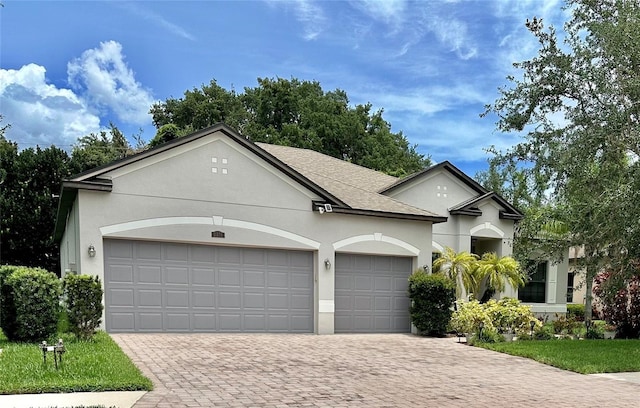 2271 50th Street Cir E, Palmetto, FL 34221 - view of front of property with decorative driveway, a garage, stucco siding, and roof with shingles