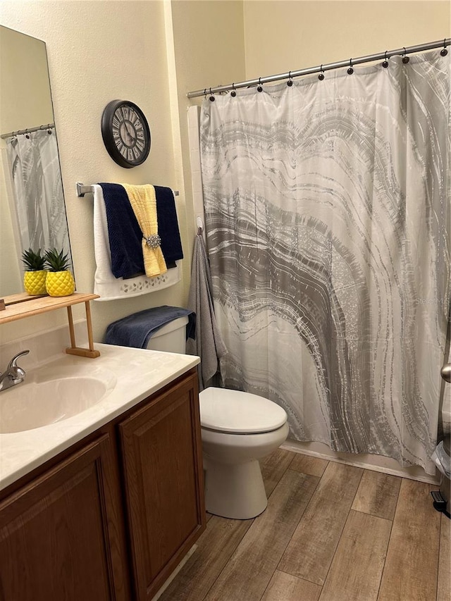 bathroom with wood-type flooring, toilet, and vanity