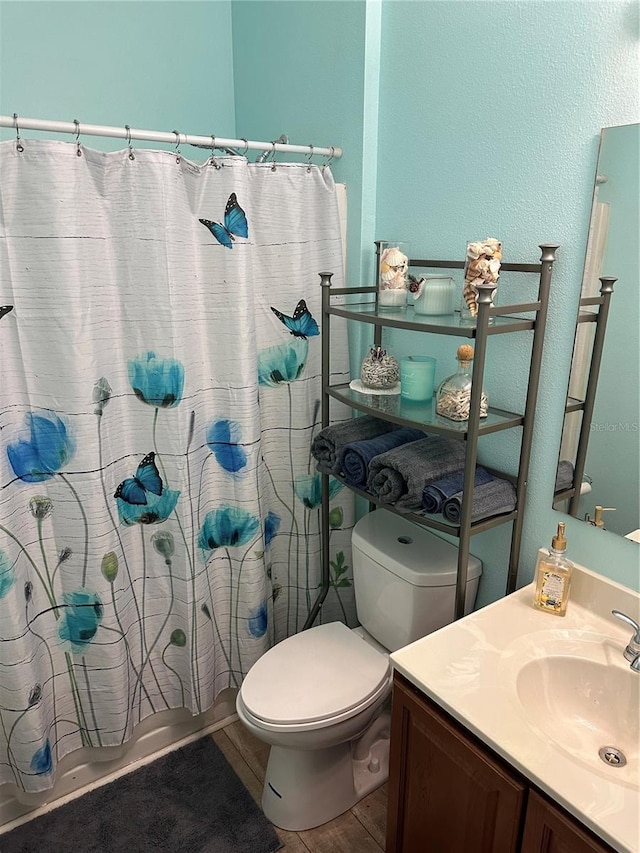 full bathroom with hardwood / wood-style floors, vanity, toilet, and shower / bathtub combination with curtain