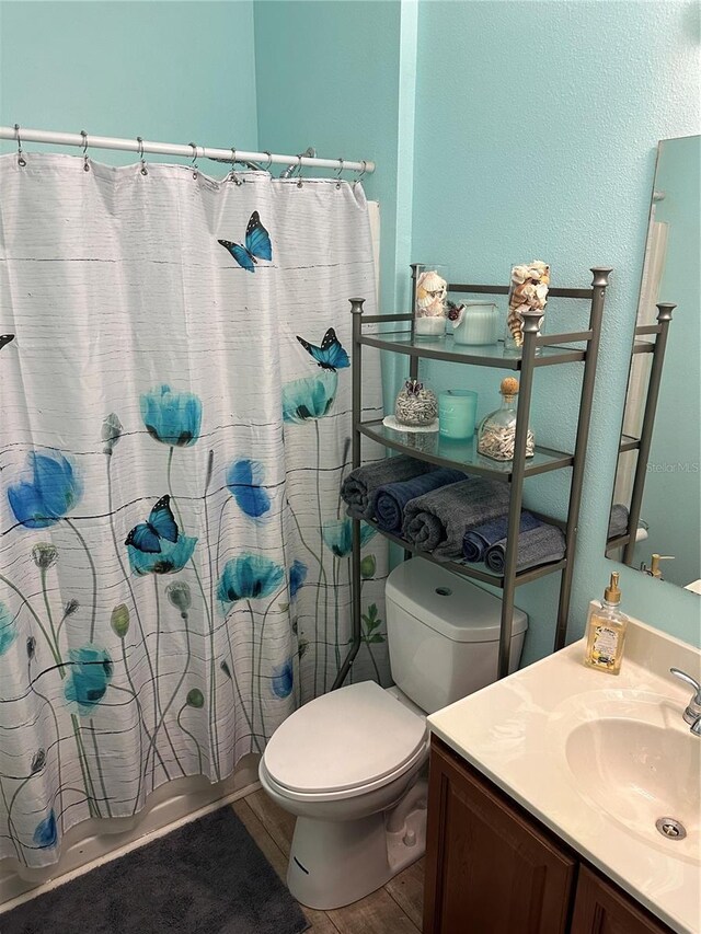 2271 50th Street Cir E, Palmetto, FL 34221 - bathroom featuring toilet, vanity, wood finished floors, shower / bath combo, and a textured wall