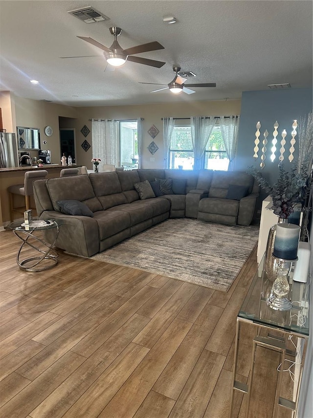2271 50th Street Cir E, Palmetto, FL 34221 - living area featuring a ceiling fan, light wood-type flooring, and a textured ceiling