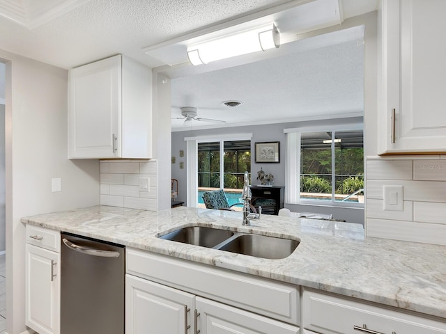 kitchen featuring dishwasher, backsplash, sink, and white cabinets