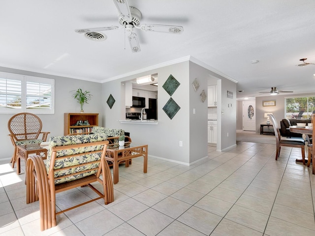 dining room with a wealth of natural light, ceiling fan, light tile patterned floors, and ornamental molding