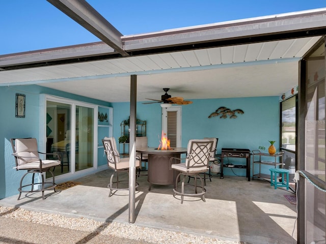 view of patio / terrace with ceiling fan and a fire pit