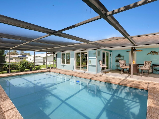 view of swimming pool with glass enclosure, a patio, and ceiling fan