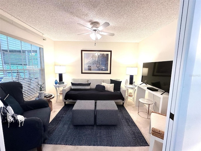 living room with a textured ceiling, a ceiling fan, and light colored carpet