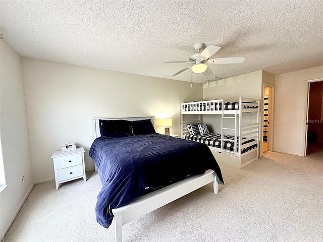 bedroom featuring ceiling fan, a textured ceiling, and light colored carpet